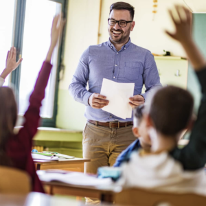 Substitute teacher with students and their hands raised